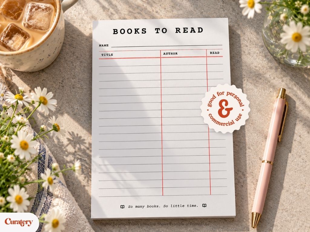 A "Books to Read" notepad with columns for name, title, author, and read, featuring a sticker that says "good for personal & commercial use" and the phrase "So many books. So little time." at the bottom, is displayed on a concrete surface next to a cup of iced coffee, daisies, and a pink pen.
