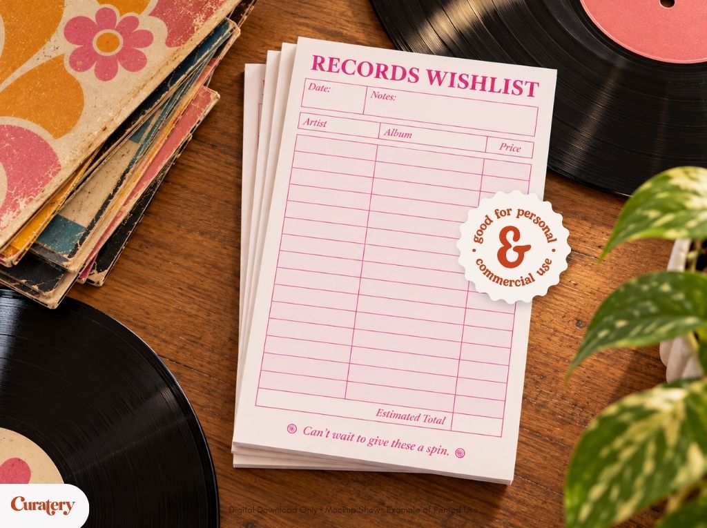 A stack of pink-lined "RECORDS WISHLIST" notepads, featuring sections for artist, album, and price, and a circular sticker stating "good for personal & commercial use", rests on a wooden surface alongside vintage record sleeves, vinyl records, and a plant.